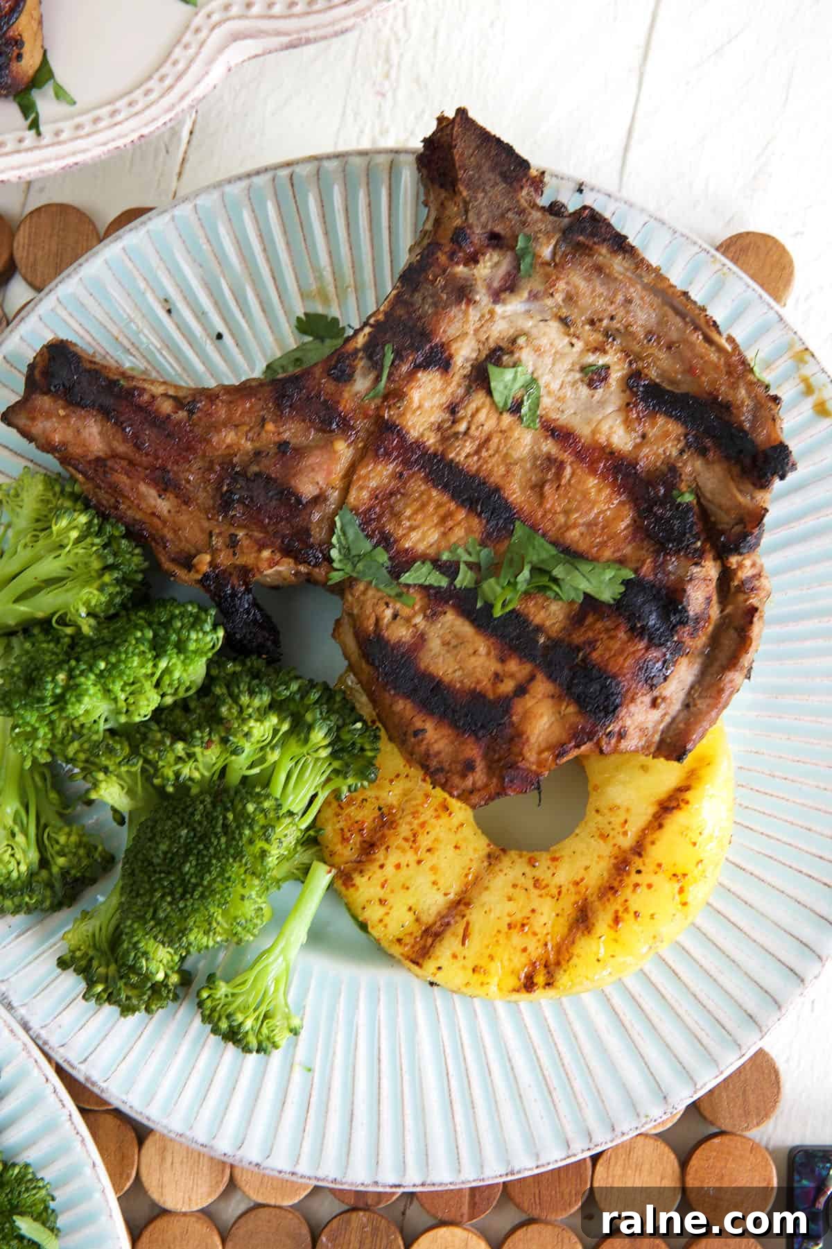 Grilled Pineapple with Chili-Lime Glaze 4 Grilled pork chop with pineapple and broccoli on a blue plate