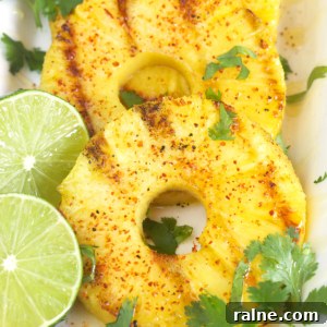 Grilled Pineapple with Chili-Lime Glaze 5 Three slices of grilled pineapple with cilantro sprigs and two lime slices.