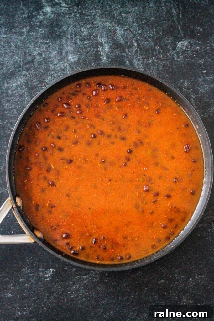 Zesty Spiced Black Beans Recipe for Bold Flavor 5 Broth added to the skillet of beans.