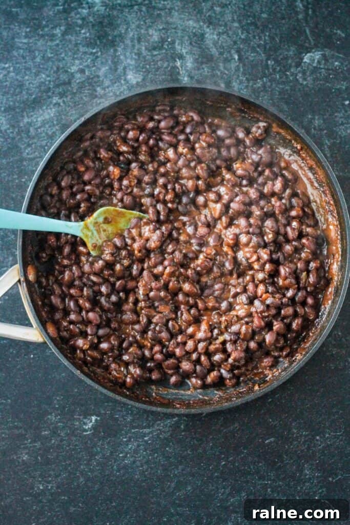 Zesty Spiced Black Beans Recipe for Bold Flavor 6 Simmered and thickened black beans in a skillet.