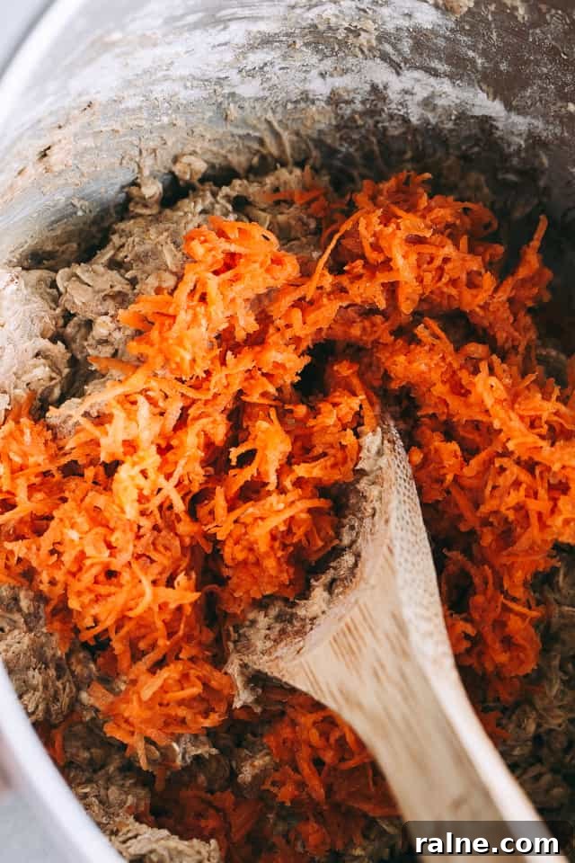 Combining shredded carrots with cookie dough.