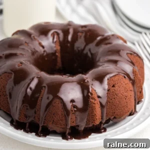 Chocolate Bundt Cake on a white plate and topped with chocolate frosting.