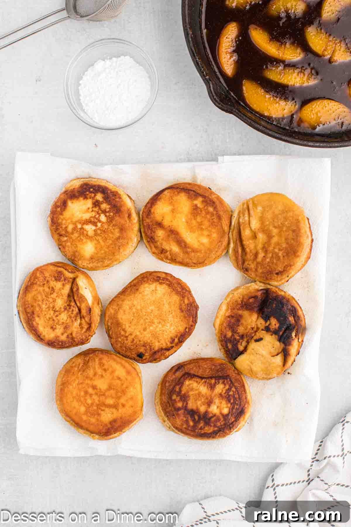 Crispy Fried Peach Cobbler: Southern Dessert Recipe 6 Fried biscuits on a plate lined with paper towels.