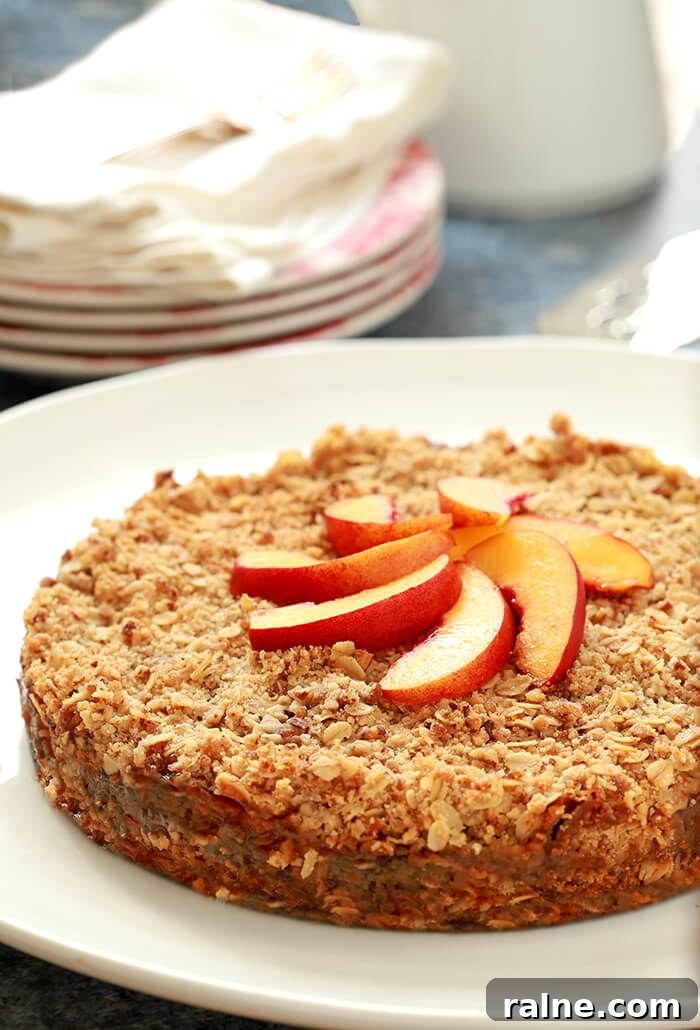 Peach and Pecan Double-Crust Crisp Recipe 3 Fresh Double Crusted Peach and Pecan Crisp on a White Serving Plate Garnished with Peach Slices