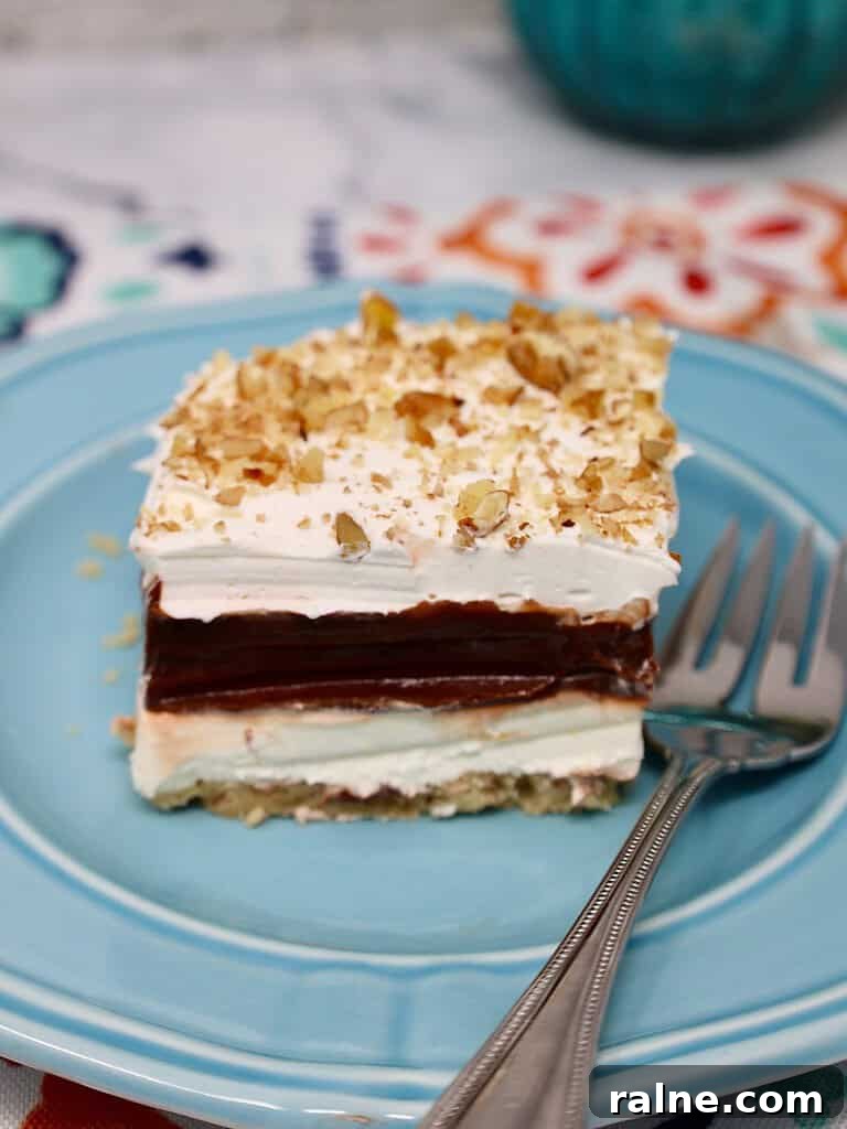 a beautiful slice of four layer delight dessert lasagna with a fork reading to eat
