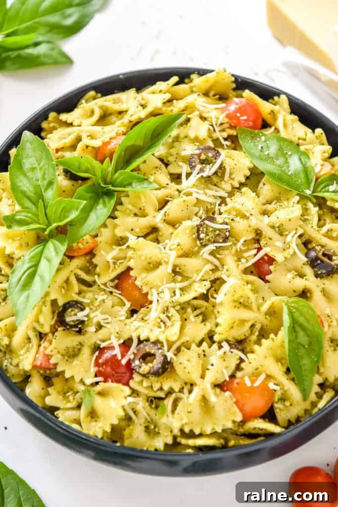 easy pesto pasta salad with fresh basil leaves on top.