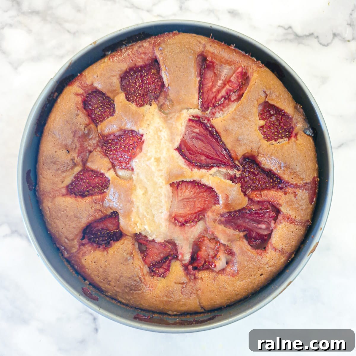 Light Mascarpone Strawberry Cake Without Butter — Moist Summer Dessert 13 A baked strawberry cake in a round cake pan.
