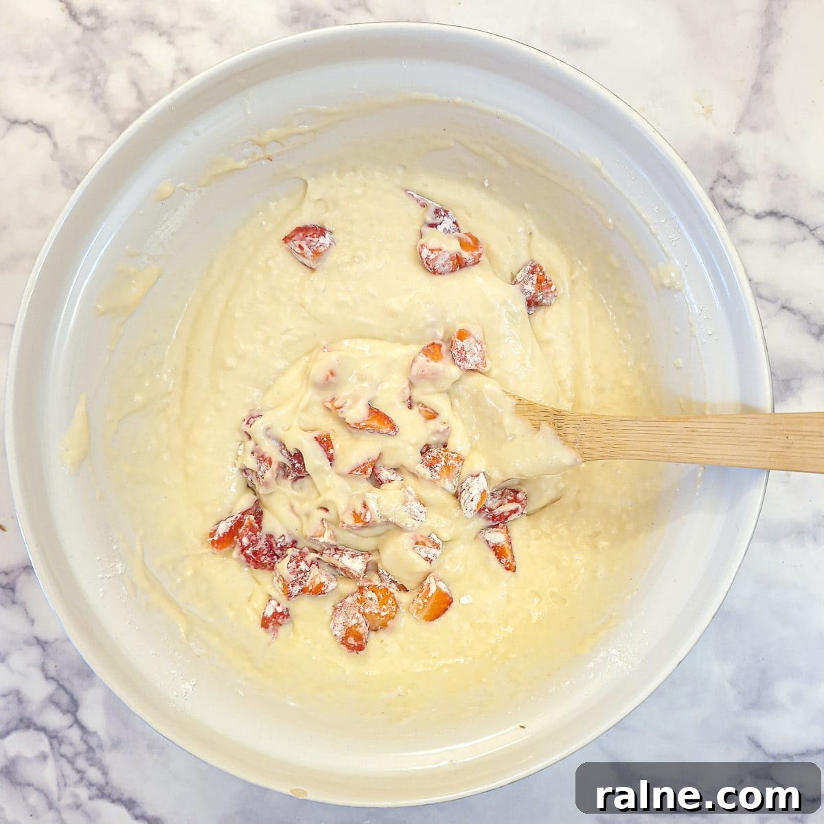 Light Mascarpone Strawberry Cake Without Butter — Moist Summer Dessert 9 Flour-coated strawberries being mixed into the cake batter.