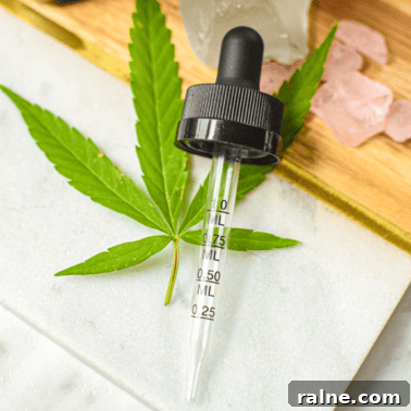 A picture of a cannabis tincture and a hand pulling out the dropper.
