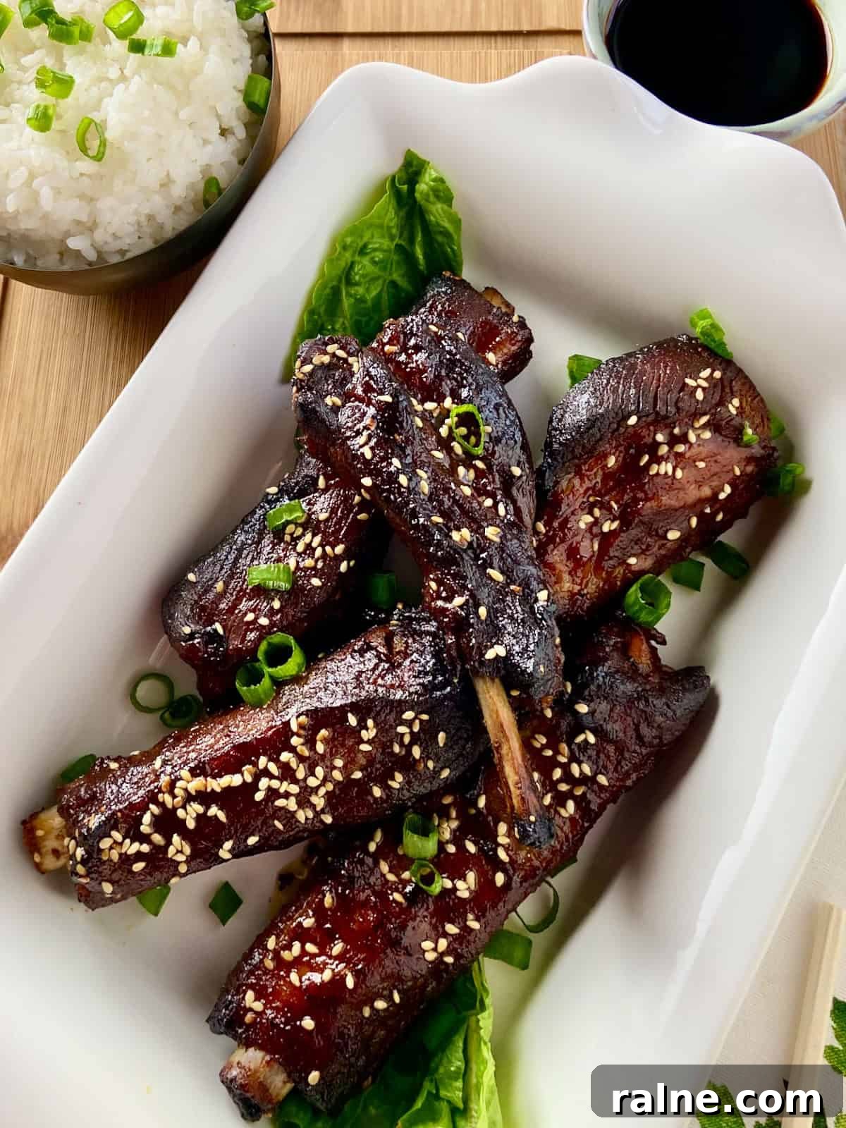 Sticky Asian-Style Pork Spareribs Recipe 3 Asian sticky pork ribs in white serving platter.