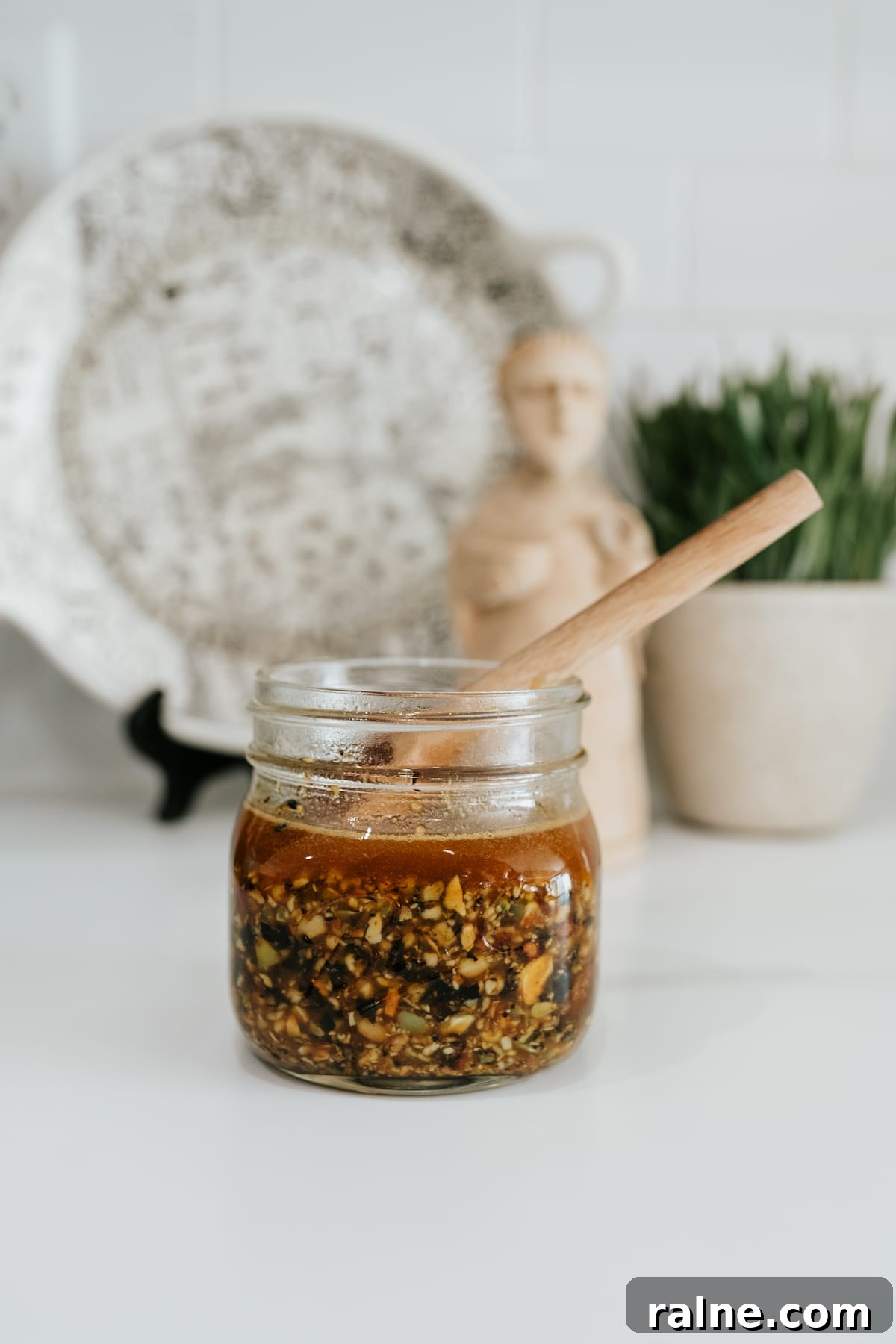Salsa macha in a small mason jar with a wooden spoon.