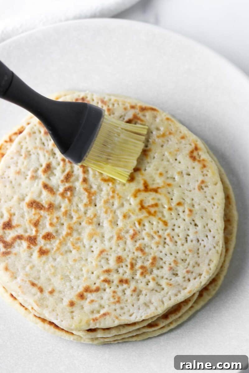 Soft Swedish Tunnbröd Recipe: How to Make Traditional Flatbreads 11 Flatbreads being brushed with melted butter.