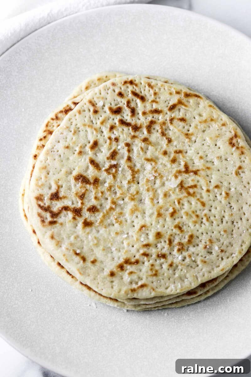 Soft Swedish Tunnbröd Recipe: How to Make Traditional Flatbreads 12 Stack of flatbreads on a white plate.