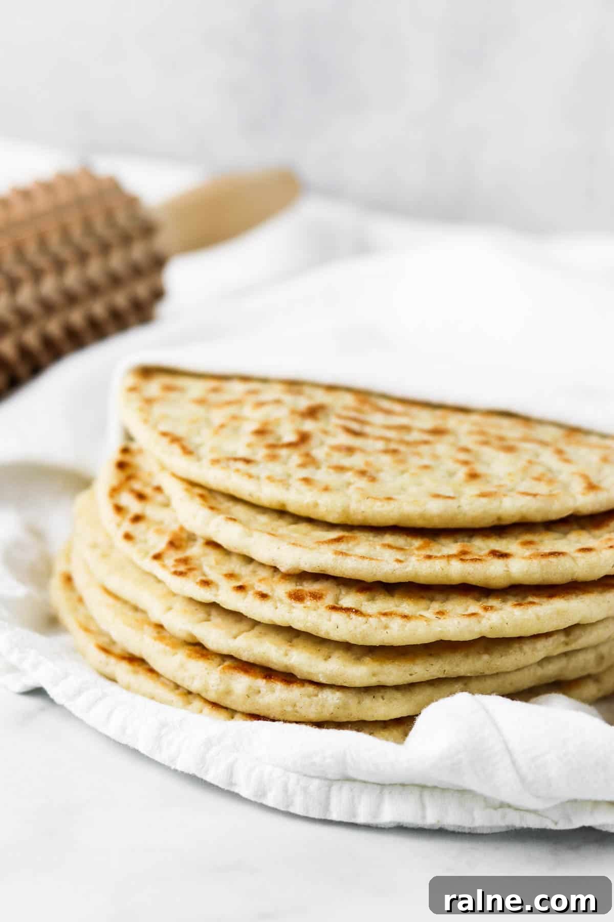 Soft Swedish Tunnbröd Recipe: How to Make Traditional Flatbreads 14 Stack of flatbreads on a towel.