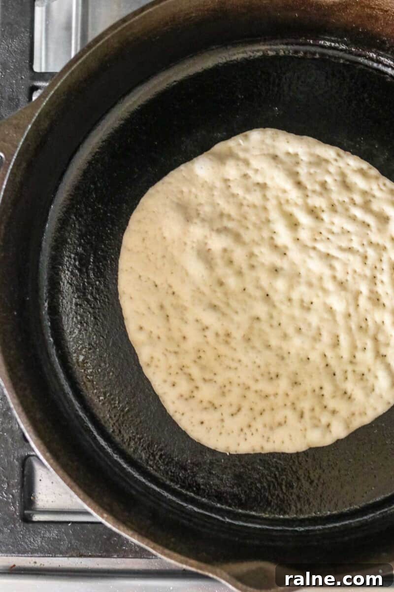 Soft Swedish Tunnbröd Recipe: How to Make Traditional Flatbreads 9 Flatbread cooking in a cast iron skillet.