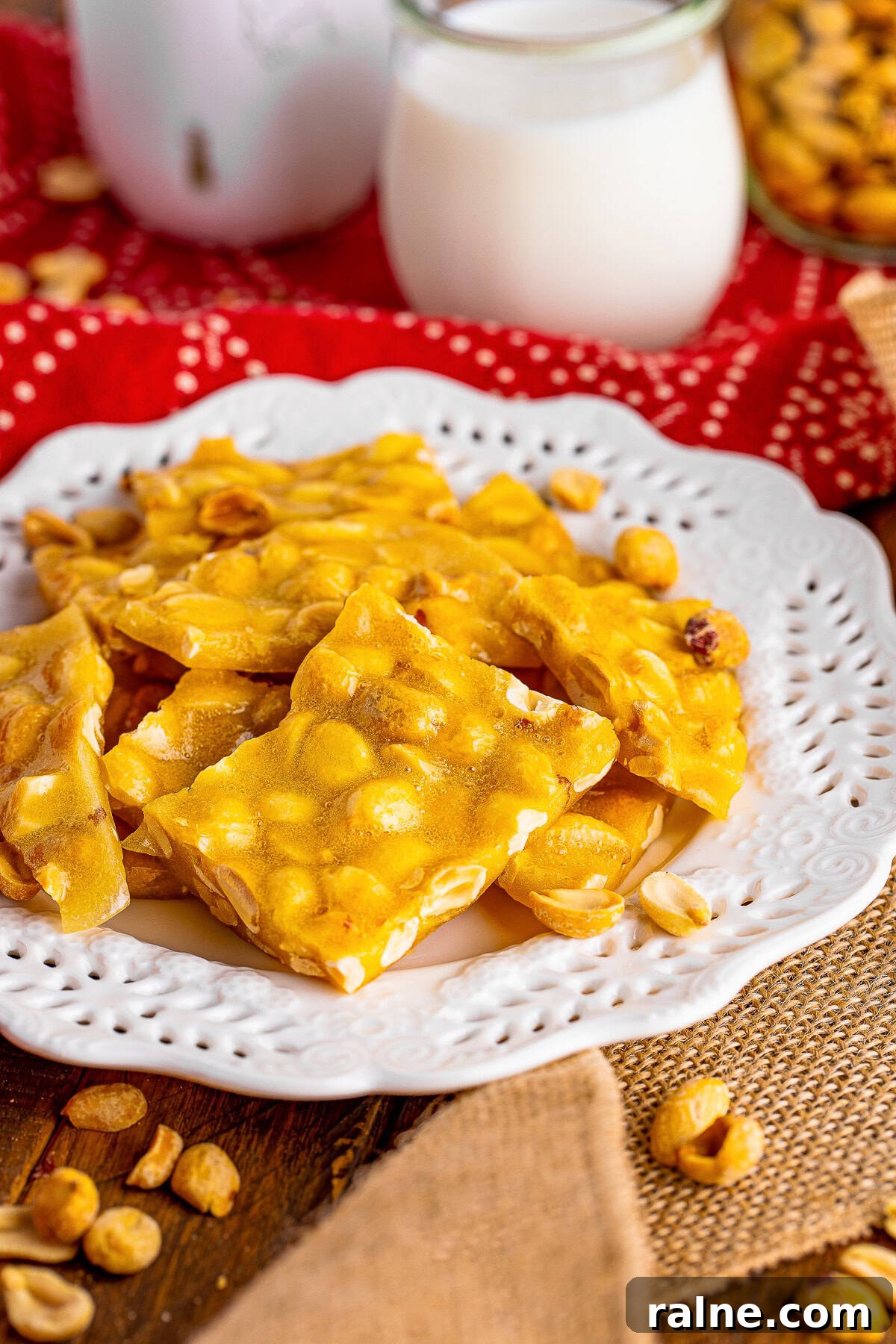 pieces of Microwave Peanut Brittle served on a white plate with red linen