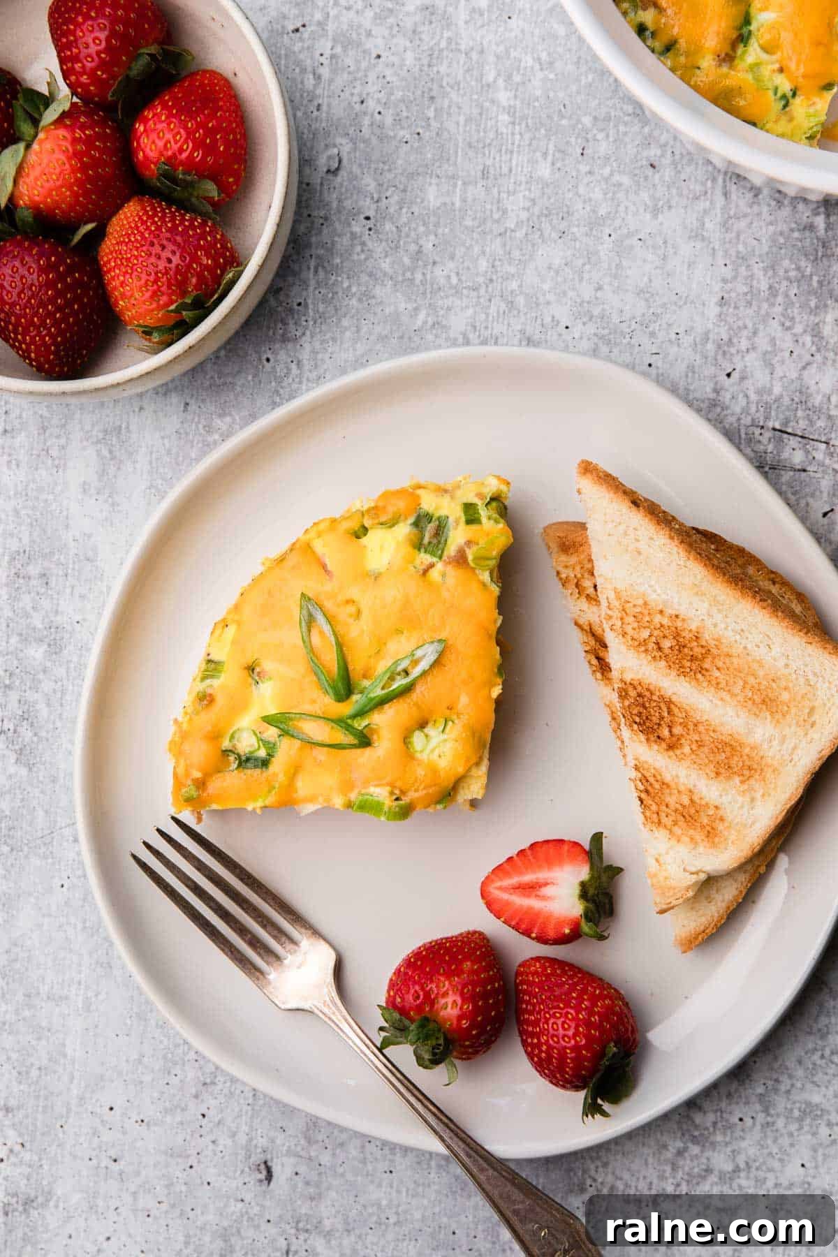 Instant Pot Egg and Sausage Breakfast Casserole 2 Plate with breakfast casserole, toast and strawberries.