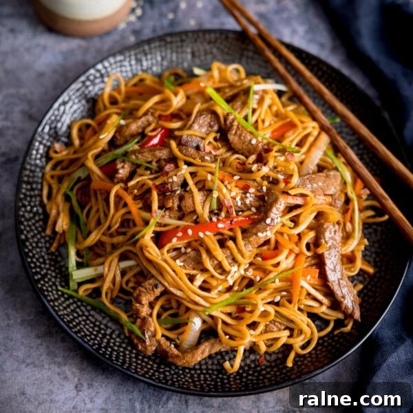 Singapore Stir-Fry Noodles with Curry and Shrimp 11 Square image of beef teriyaki noodle stir fry on a black plate.