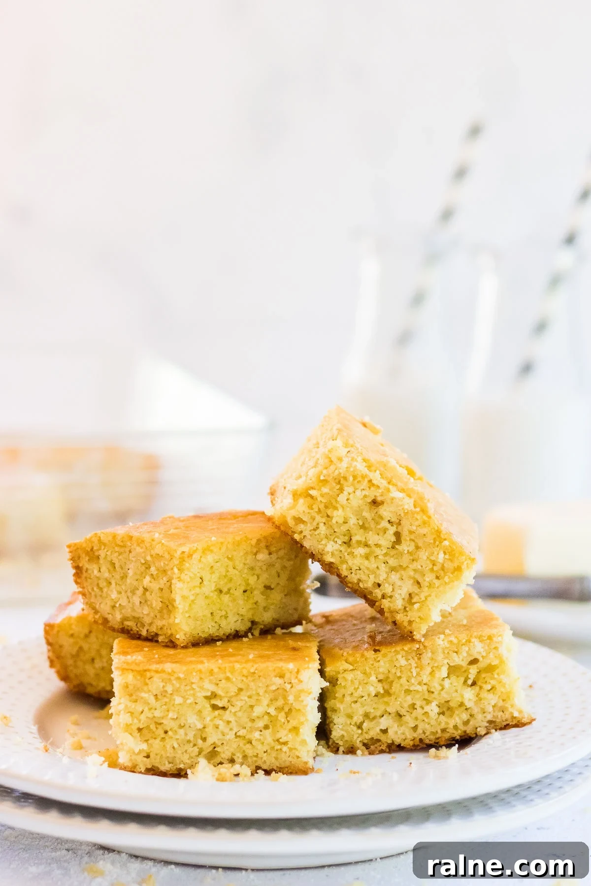 Buttermilk cornbread cut n squares and stacked on a plate.