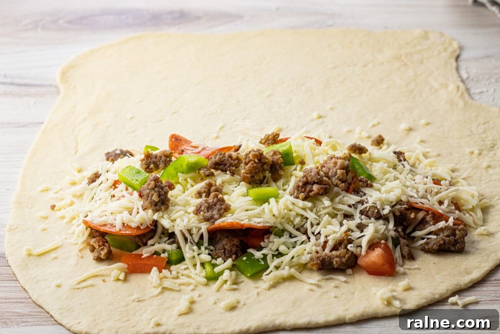 pizza dough rolled out into a circle with half filled with toppings