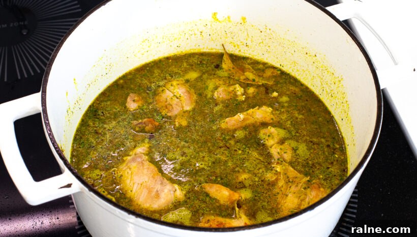 Authentic Latin-Style Chicken and Rice Recipe 7 Chicken, rice and sofrito in a pot cooking.