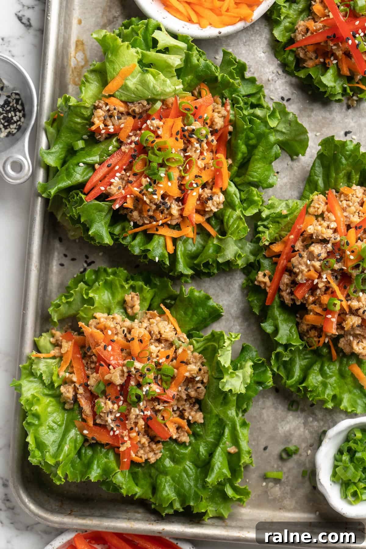 Whether you’re looking for a no-cook dinner or something light and refreshing, you’re going to love these easy Asian-inspired lettuce wraps! Overhead view of walnut meat lettuce wraps on sheet pan
