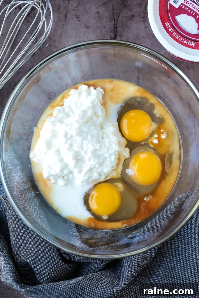 Cottage Cheese Pancakes are a tasty way to get more protein into your breakfast! Fluffy, protein packed pancakes that melt in your mouth! eggs and cottage cheese in a bowl for making pancakes