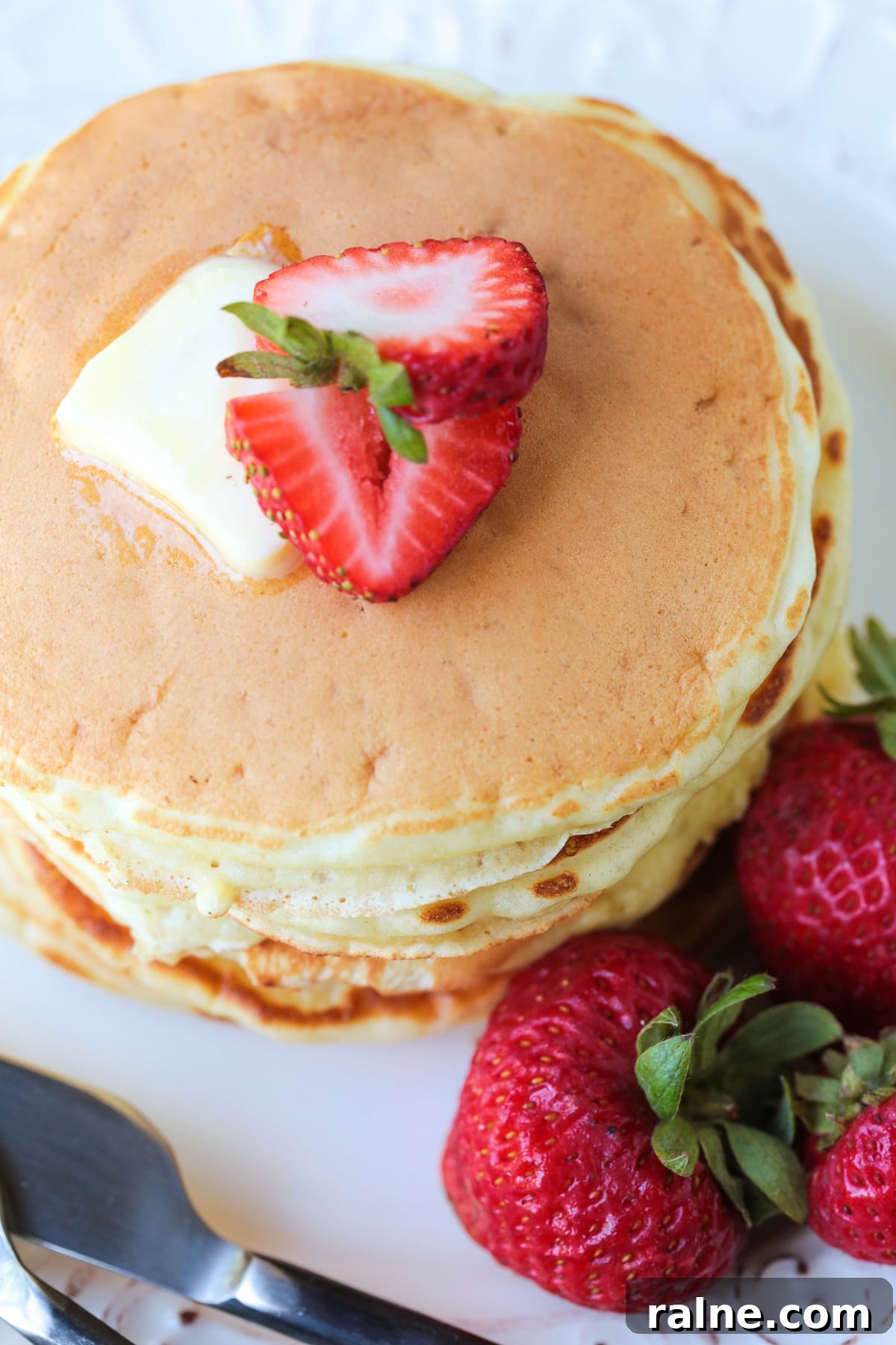 Cottage Cheese Pancakes are a tasty way to get more protein into your breakfast! Fluffy, protein packed pancakes that melt in your mouth! pancakes stacked on a plate with strawberries