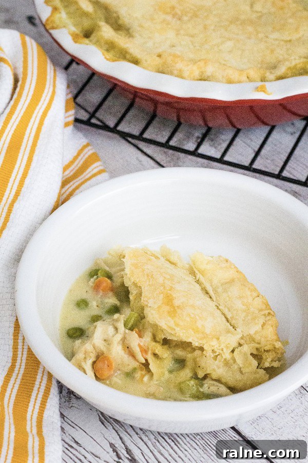 Instant Pot Chicken Pot Pie with Pie Crust or Biscuit Topping 8 white bowl filled with a serving of Instant Pot chicken pot pie topped with a flaky pie crust