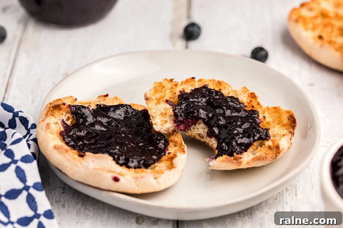How to Make Homemade Blueberry Butter (Smooth & Spreadable) 7 English muffin with blueberry butter on it.