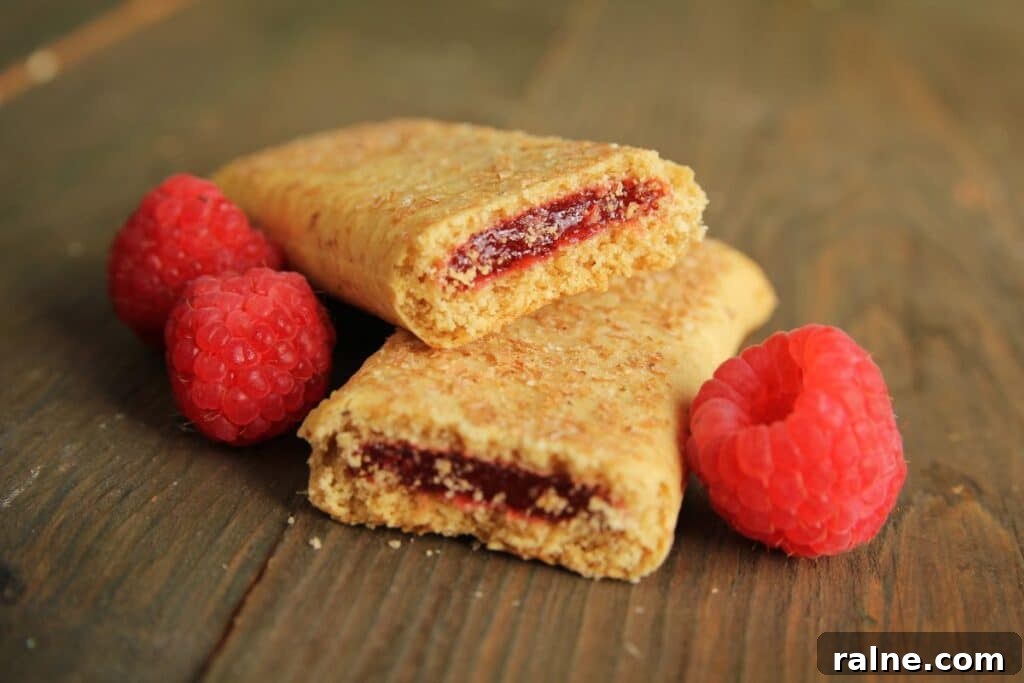 Nutri-Grain Bars: A Dietitian’s Honest Review of Nutrition 2 A cereal bar broken in half with raspberries.