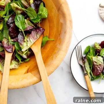 A simple French green salad in a wood bowl.