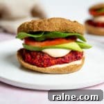 A gluten free beet and sweet potato burger topped with sriracha mayo sauce.