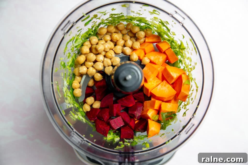 Process shot showing the ingredients for the gluten free veggie burgers in a food processor.