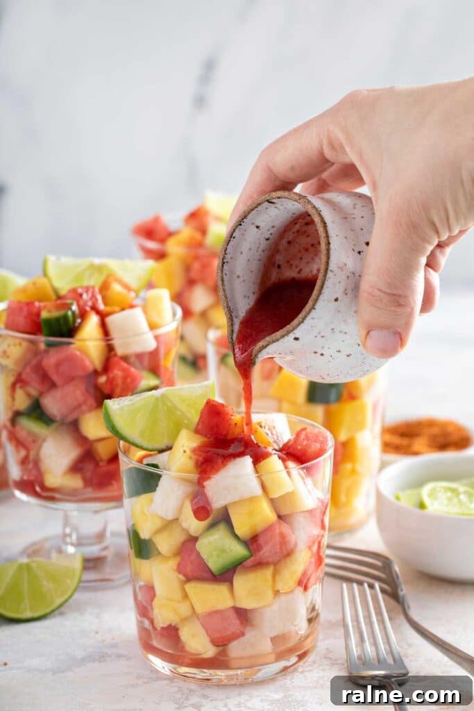 Authentic Mexican Fruit Cups (Vasos de Fruta) — Street Snack Recipe 2 Pouring Mexican chamoy sauce over a cup of fresh fruit