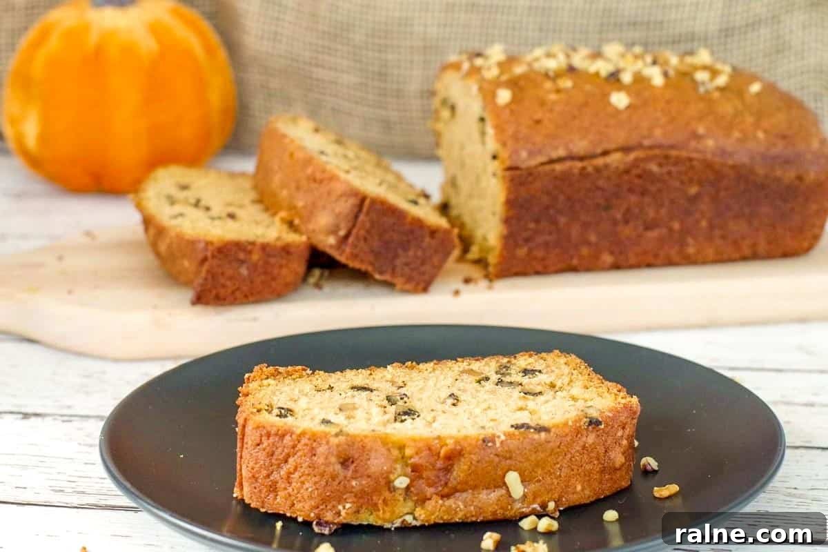 Dairy-Free Pumpkin Walnut Bread Recipe 2 A slice of Dairy-free Pumpkin Bread on a black plate with more in the background.