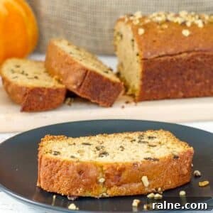 Dairy-Free Pumpkin Walnut Bread Recipe 17 A slice of Dairy-free Pumpkin Bread on a black plate with more in the background.