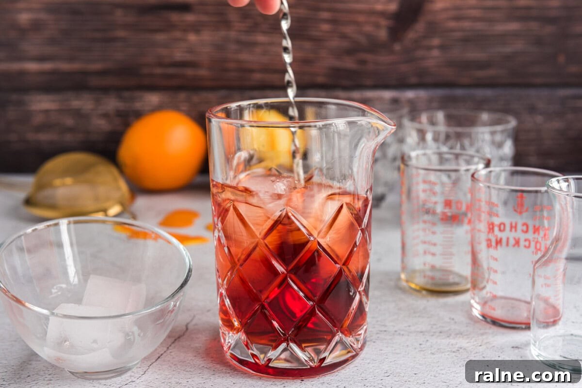 pouring ingredients for Negroni into a mixing glass
