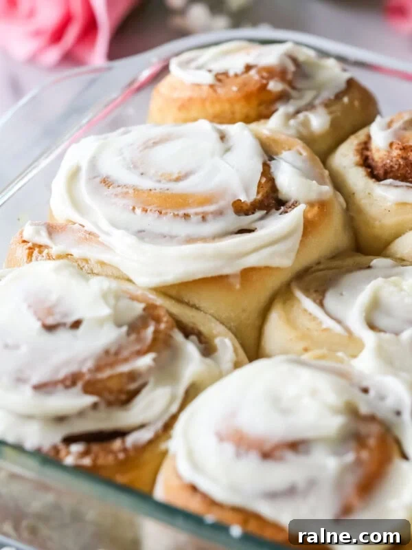 Hearty Breakfast Casserole Recipe for Busy Mornings 11 Glass dish of overnight cinnamon rolls frosted with cream cheese frosting.