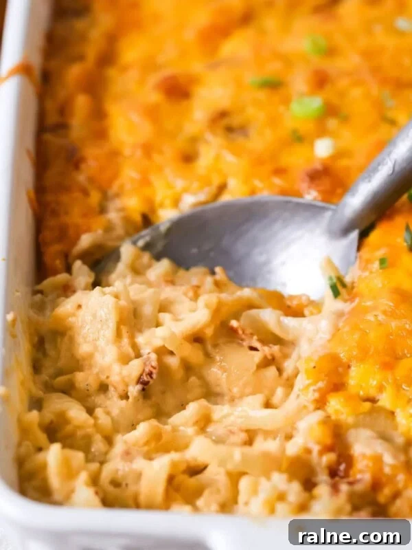 Hearty Breakfast Casserole Recipe for Busy Mornings 12 Spoon scooping a serving of hashbrown casserole out of a dish.