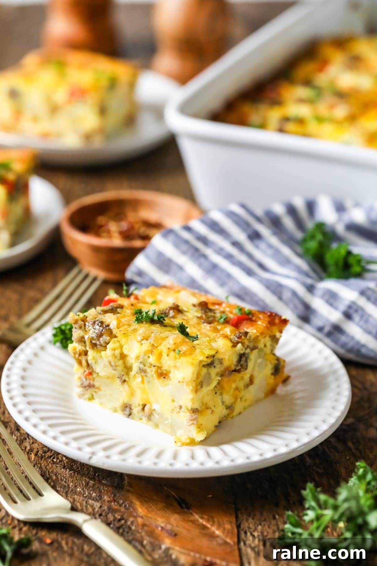 Hearty Breakfast Casserole Recipe for Busy Mornings 3 Slice of breakfast casserole made with sausage, peppers, and hash browns on a plate.