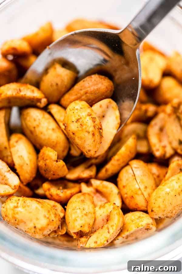 Crispy Homemade Air-Fried Peanuts Recipe 9 Tasty roasted Air Fryer peanuts with taco seasoning in a glass jar with a spoon.