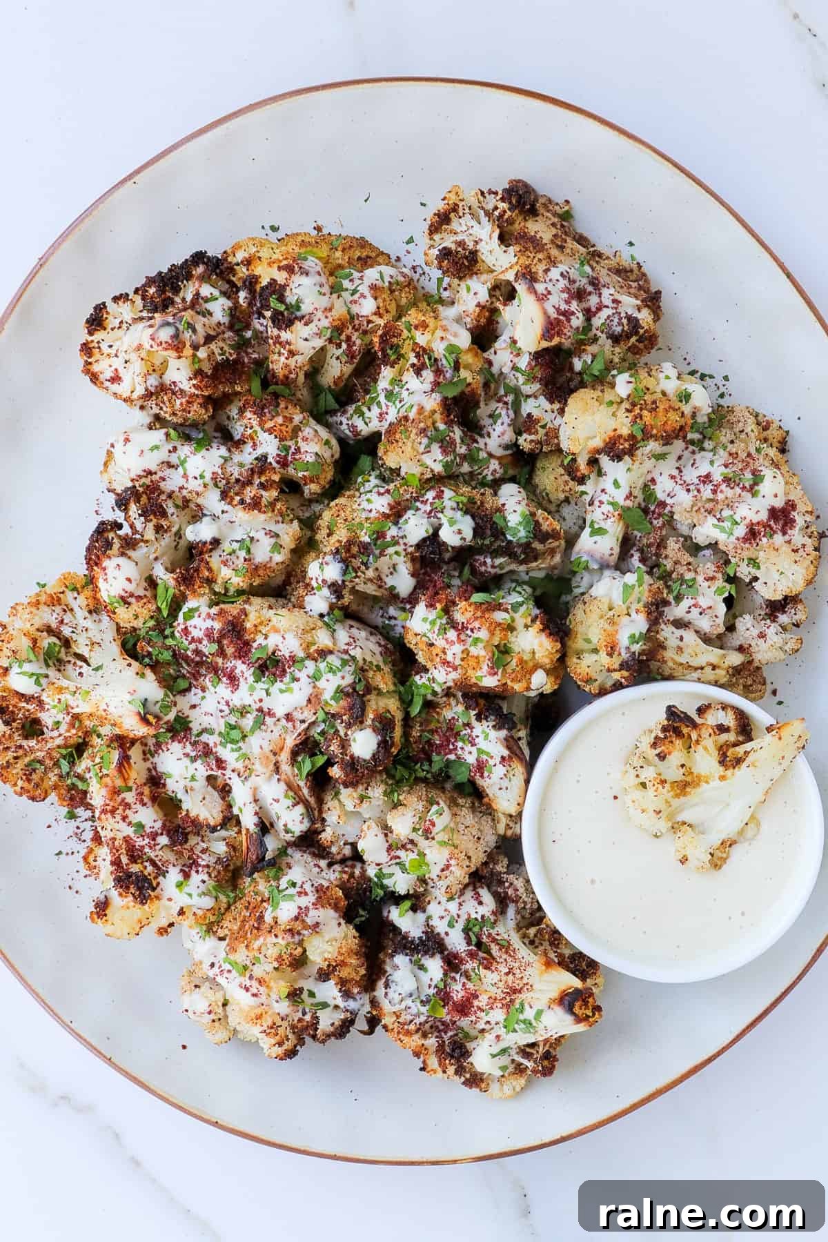 Sumac-Roasted Cauliflower with Creamy Tahini Sauce 2 Sumac cauliflower with tahini sauce drizzled and served on the side.