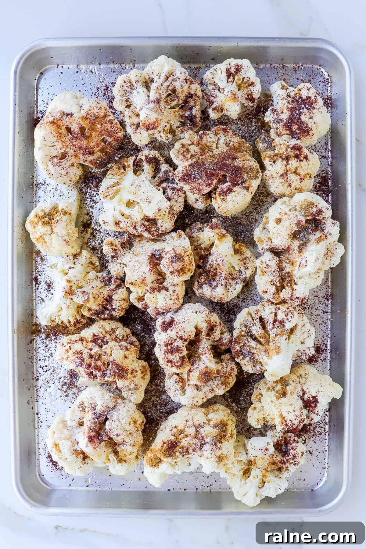 Sumac-Roasted Cauliflower with Creamy Tahini Sauce 5 Seasoned cauliflower on a baking sheet.