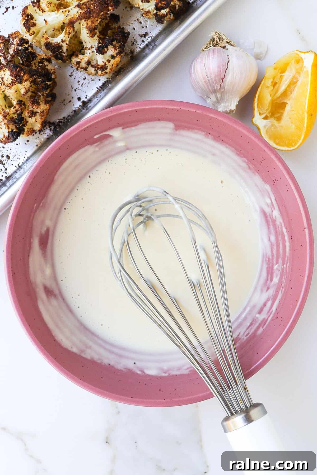 Sumac-Roasted Cauliflower with Creamy Tahini Sauce 7 Lemon tahini sauce in a bowl with a whisk.