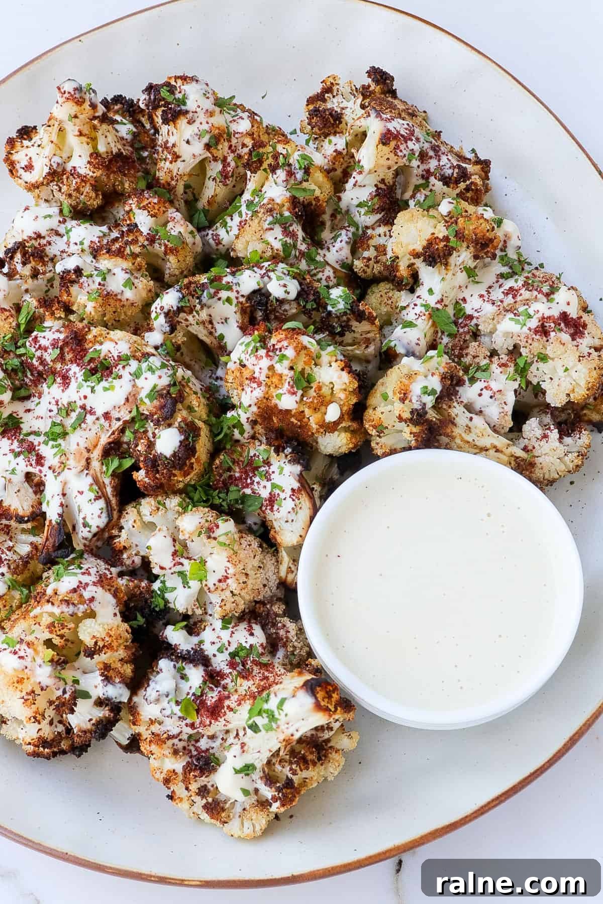Sumac-Roasted Cauliflower with Creamy Tahini Sauce 9 Side shot of roasted cauliflower on a plate with tahini.