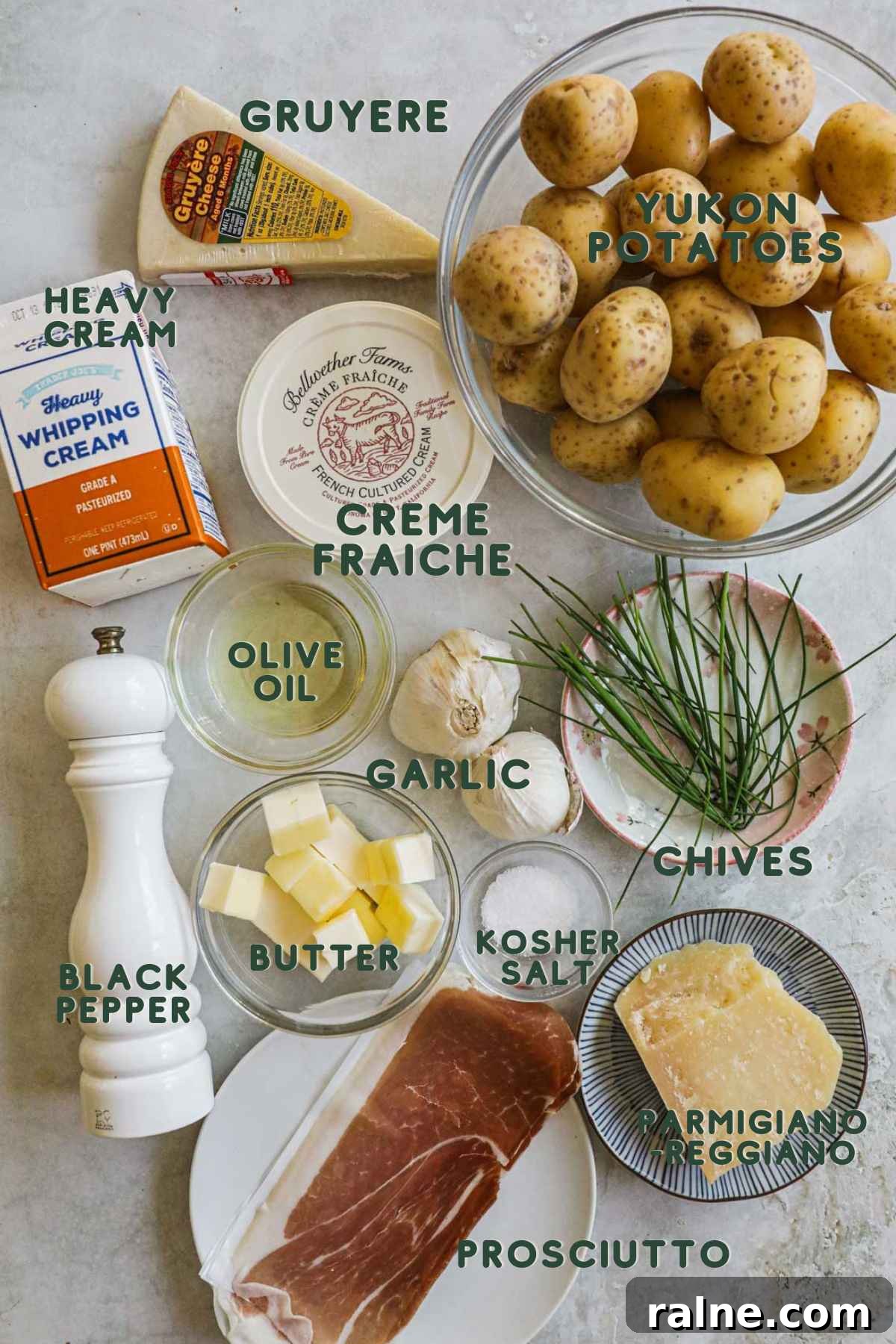 Ingredients to make twice-baked mashed potatoes, yukon potatoes, heavy cream, olive oil, garlic, chives, butter, parmigiano-reggiano, gruyere, prosciutto.