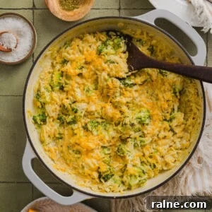 Creamy Broccoli Cheddar Orzo Bake with Parmesan Crust 9 One-pot broccoli cheddar orzo in a braiser pan on a green tile counter.