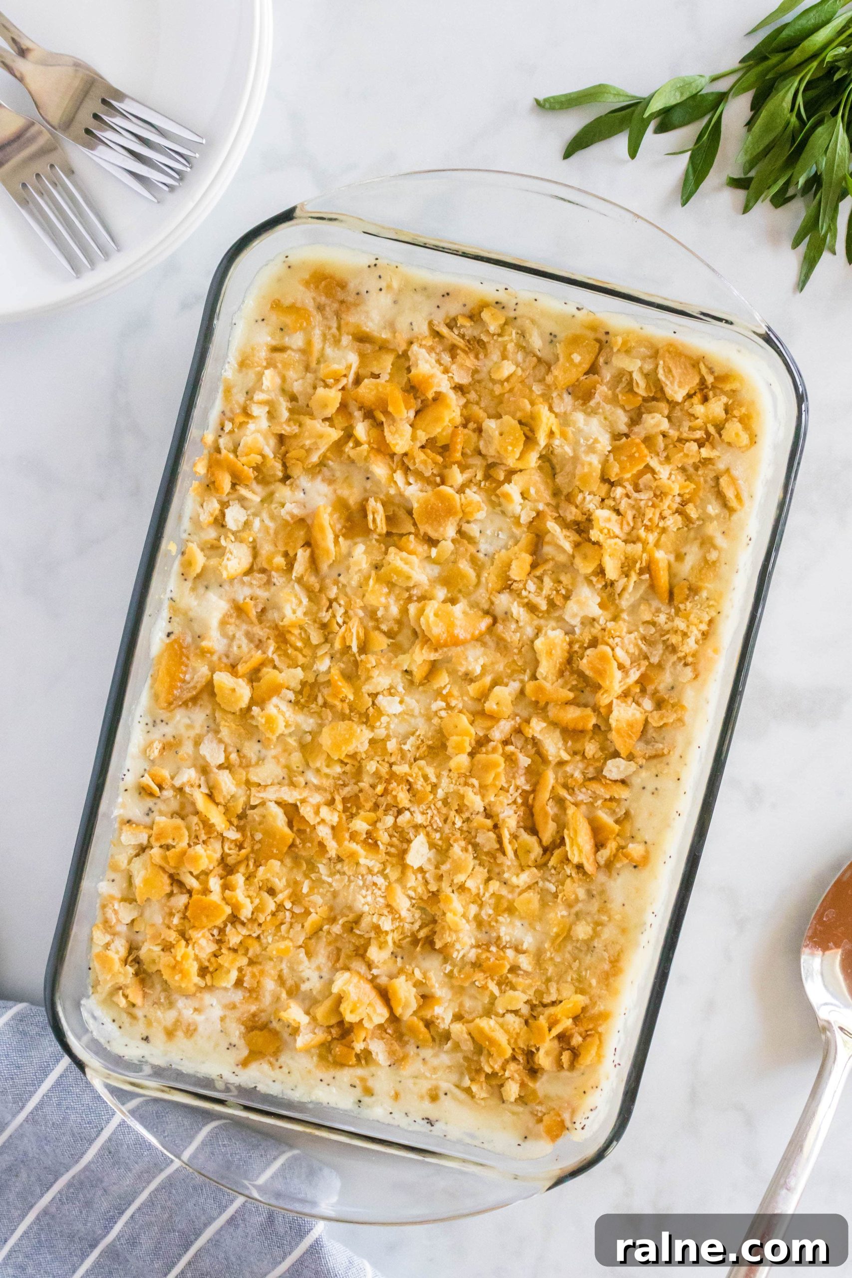 Creamy Poppy Seed Chicken Casserole with Ritz Topping 7 Overhead image of a large glass baking dish filled with creamy poppy seed chicken casserole topped with golden buttery crumbled Ritz crackers.