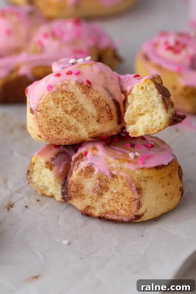 Stacked cinnamon rolls with pink frosting and soft centers